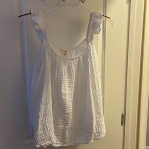 Sleeveless shirt with ruffles on the straps. Bottom of shirt flare.